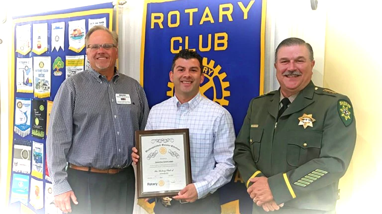 Rotarian Mark Hornstra, Officer of the Year Aaron Lopez and Sheriff John D’Agostini, left to right, are all smiles after Det. Lopez accepted his award. Village Life photo by Noel Stack